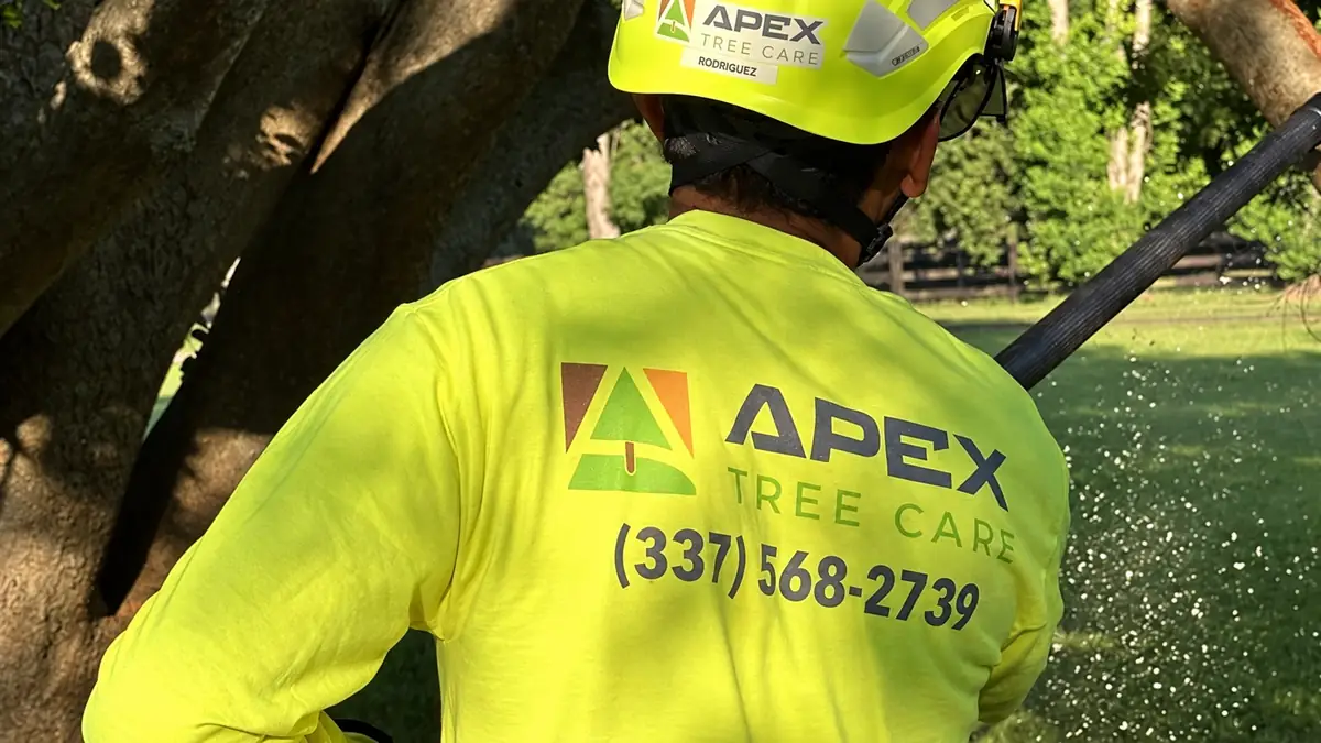 The back of an Apex crew shirt with the logo and phone number, at work in a yard